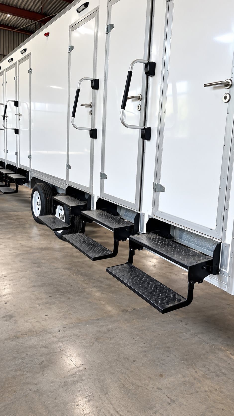 Stall doors and fold-down steps on a 22 ft six-stall shower and restroom combination trailer